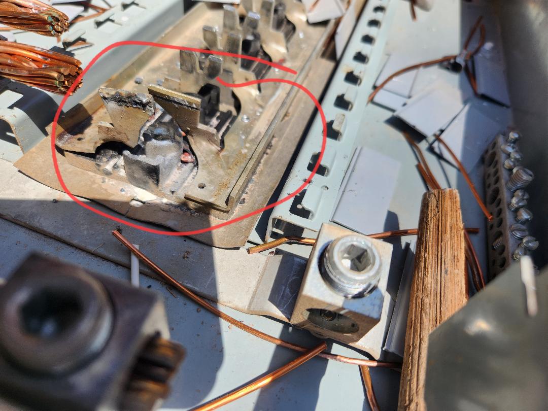 Damaged meter socket with burned jaws showing heat damage, marked for replacement
