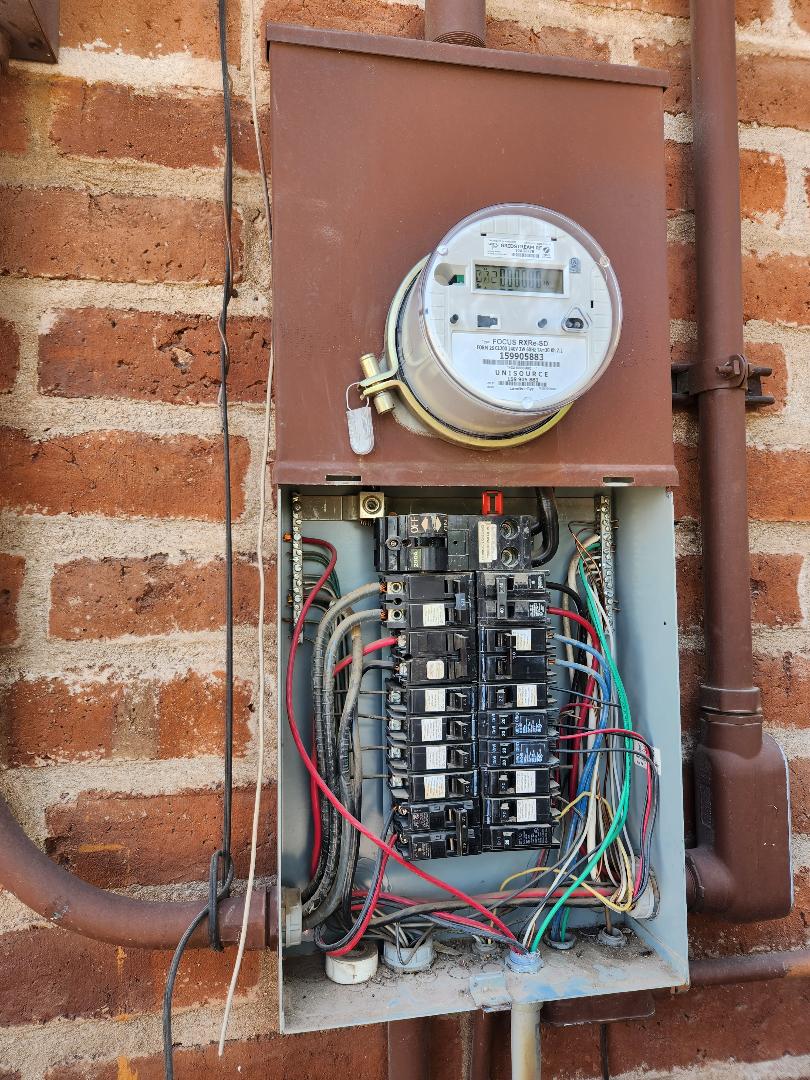 Existing overloaded residential panel before upgrade, deadfront removed showing crowded branch circuits