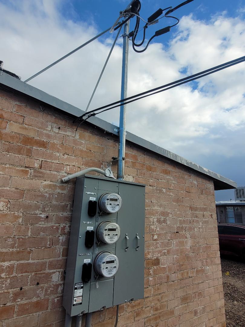 Wide shot of completed service upgrade showing new mast reaching the service drop